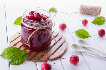 Delicious apple jam with whole apples on a white background.