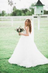 Portrait of stunning bride with long hair posing with great bouquet