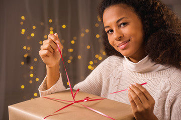 Young woman unwraping a present
