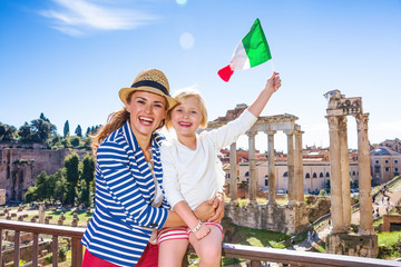 mother and child tourists in front of Roman Forum rising flag