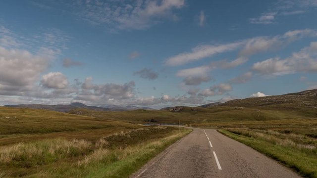 POV shot from a camera attached to the front of a vehicle driving through beautiful empty roads in the scottish highlands