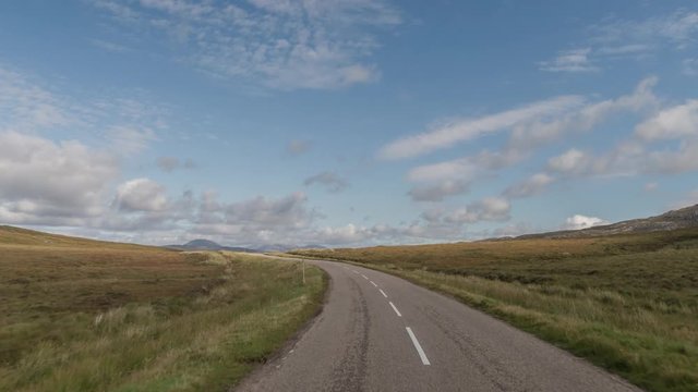 POV shot from a camera attached to the front of a vehicle driving through beautiful empty roads in the scottish highlands