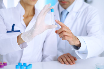 Team of  scientific researchers in laboratory studying substances or blood sample. New vaccine for pharmacology industry is s almost ready. Medicine and science concept