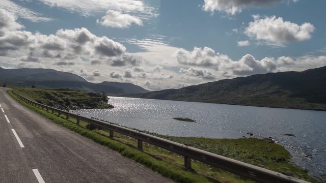 POV shot from a camera attached to the front of a vehicle driving through beautiful empty roads in the scottish highlands