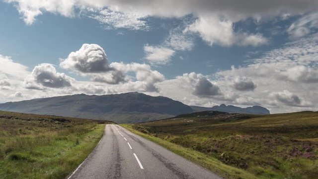 POV shot from a camera attached to the front of a vehicle driving through beautiful empty roads in the scottish highlands