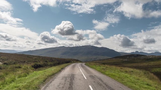 fast motion hyperlapse POV shot from a camera attached to the front of a vehicle driving through beautiful empty roads in the scottish highlands