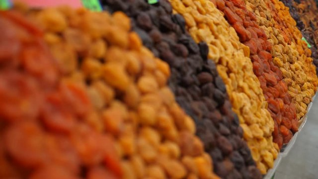 Spices, nuts, dried fruits on display at market on the counter, 4k, slow-motion