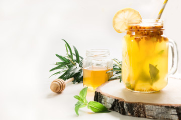 Healthy drink of seabuckthorn, lemon and mint in mason jar on white.