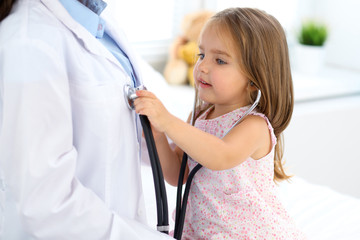 Happy little girl at  health exam at doctor office. Medicine and health care concept