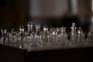 chess game with glass pieces in light