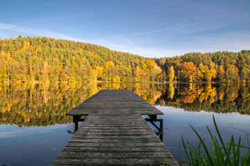 Steg am Blaibacher See im Herbst mit Spiegelung im Bayerischen Wald