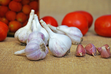 Garlic and tomatoes. Canned tomatoes. Garlic on a background of tomatoes.