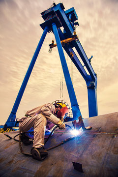 A welder at a shipyard