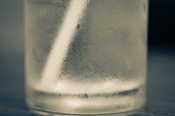 close up of glass water cold with straw on blurred background