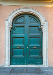 Ancient green door with golden handles in Rome, Italy