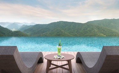 Swimming pool terrace with mountain view 3d rendering image.Furnished with rattan and wooden furniture. There are surrounding with nature and mountain