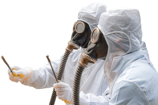 Two men in bio-hazard suits and gas masks with isolated white background. They both wear gas masks with flexible rubber breathing tubes. One of them holds a pair of rusty steel bar.