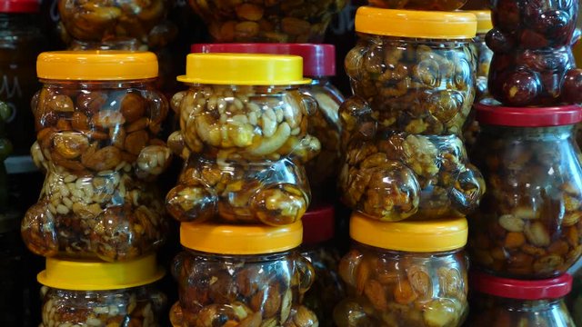 Spices, nuts, dried fruits on display at market on the counter, 4k, slow-motion