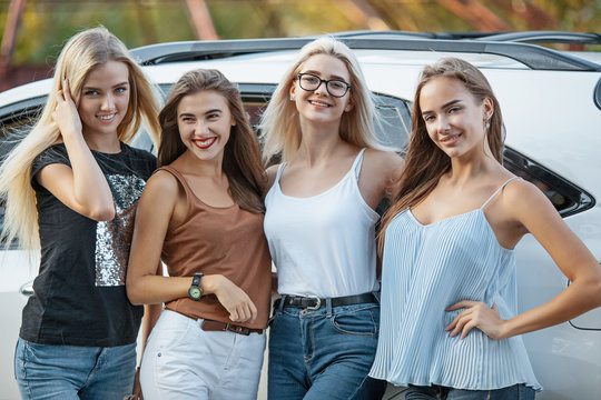 The young women standing near the car
