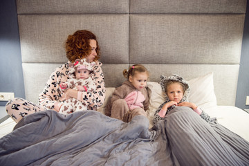 Portrait of a proud loving mother and happy little girl daughter sisters.Children wearing pajama.Laughing and having fun playing at home.Concept of love and happiness happy family.Family portrait.  
