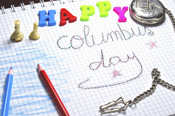 handwriting columbus day on notebook, silver pocket watch,red and blue pen,beige chess,colorful happy letter