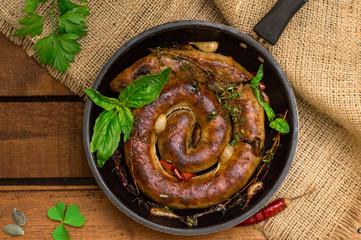 Homemade Pork Sausages in pan with thyme. Rustic wooden background. Close-up. Top view