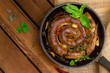 Homemade Pork Sausages in pan with thyme. Rustic wooden background. Close-up. Top view