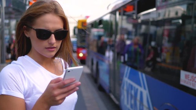 Woman texting at bus station 