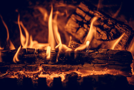 Wood in the flames of cozy fireplace