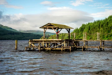 Afwasbaar fotobehang A wooden jetty at Loch Tay Highland Lodges boat station, central Scotland © anastasstyles