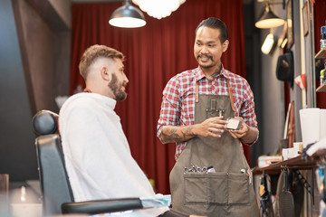 Cheerful thai barber talking with a handsome bearded man