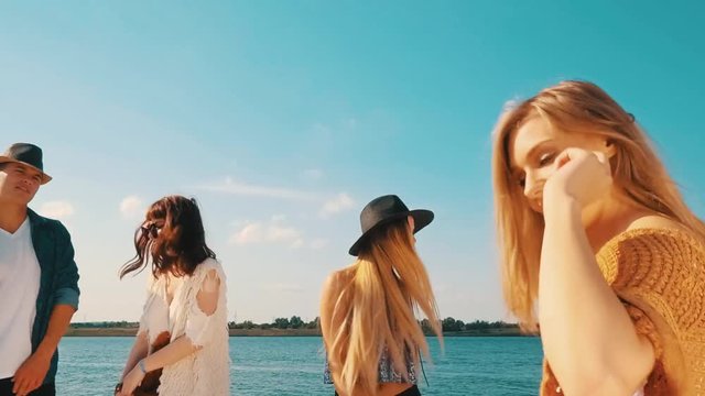Group of friends dancing and celebrating on beach