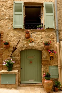 Picturesque stone facade with flowering plants medieval village of Valbonne, Provence, France
