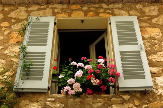 geraniums in window in medieval village of Gourdon, Provence, France
