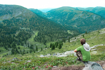 Man sitting on a mountain for watching scenic views alone, success and peace concept