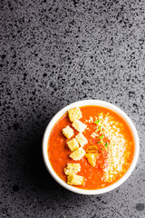 Homemade tomato and basil soup with cheese and croutons. Top view, copy space. 