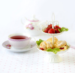 Cream puffs with berries on a stand