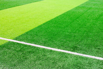 Obraz premium Photo of a green synthetic grass sports field with white line shot from above