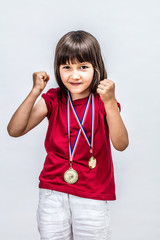 Happy successful boyish child with medals willing to win award