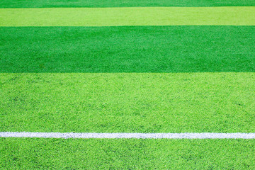 Photo of a green synthetic grass sports field with white line shot from above