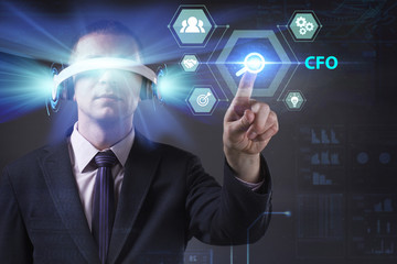 Business, Technology, Internet and network concept. Young businessman working in virtual reality glasses sees the inscription: CFO