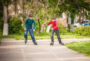 Three children on inline skates in park