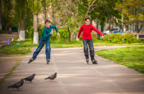 Three children on in line skates in park