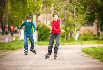 Fototapeta premium Three children on inline skates in park