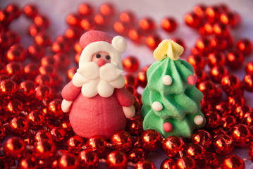 Figures of Santa Claus and New Year Tree with red garland. New year card. Merry christmas background. Xmas postcard.