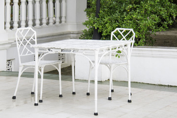 Vintage white furniture set. Table and chair in garden outdoor.