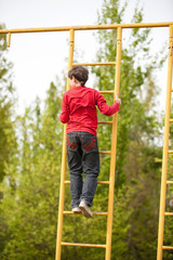 Happy kid boy on top of gymnastics ladder