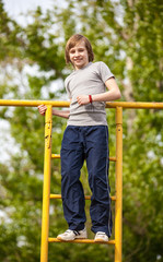 Happy kid boy on top of gymnastics ladder