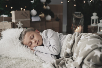Cute boy sleeping on rug