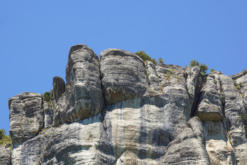 Giant sharp stones among the grass on the top of mountain meadows in vertical mountain landscape